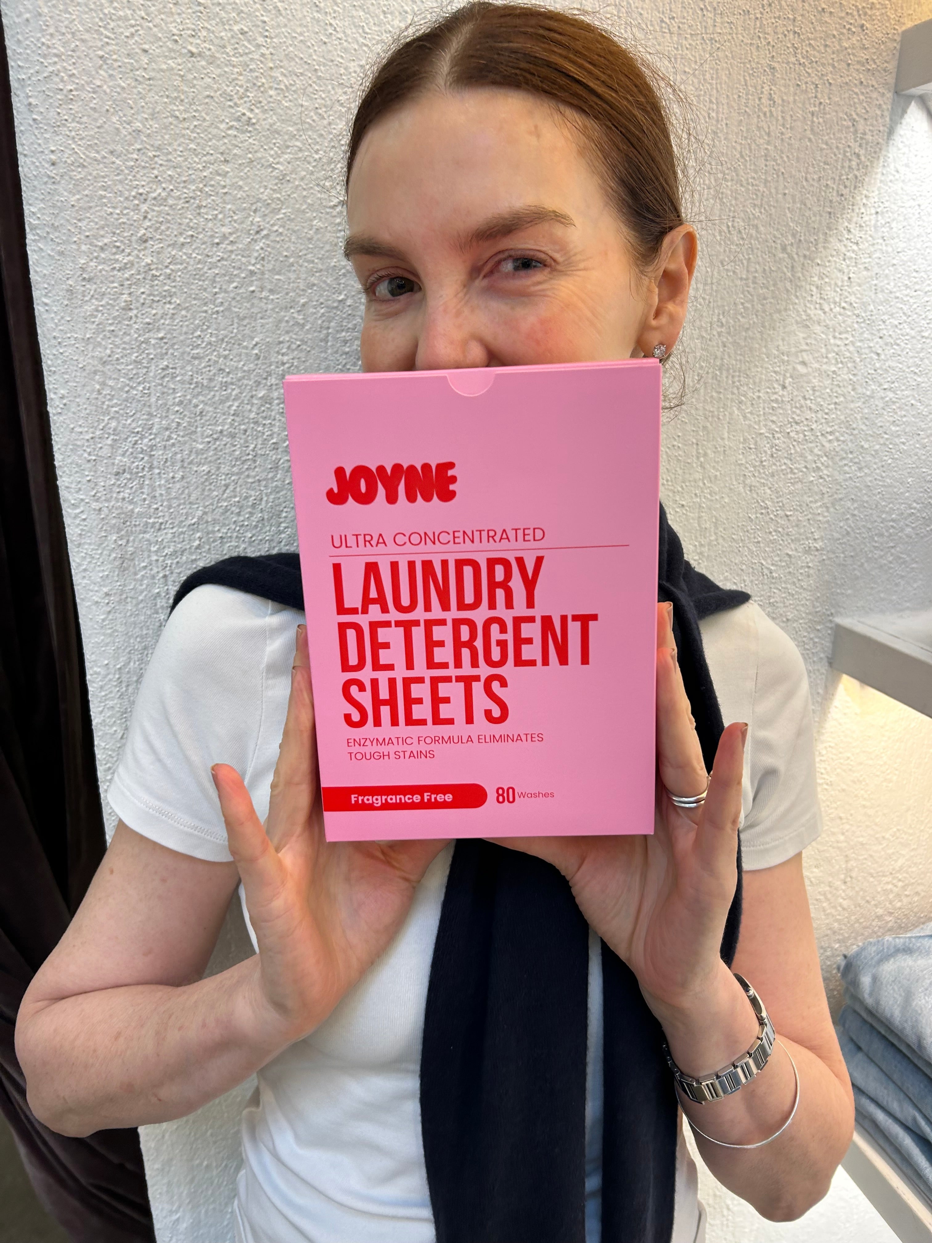 A women holding a pink box of laundry detergent sheets